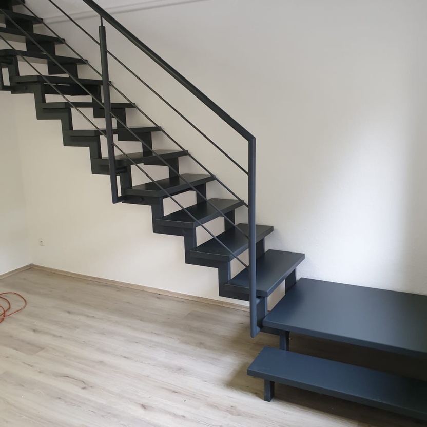 Dunkle Treppe mit schwarzen Stufe und schwarzem Geländer