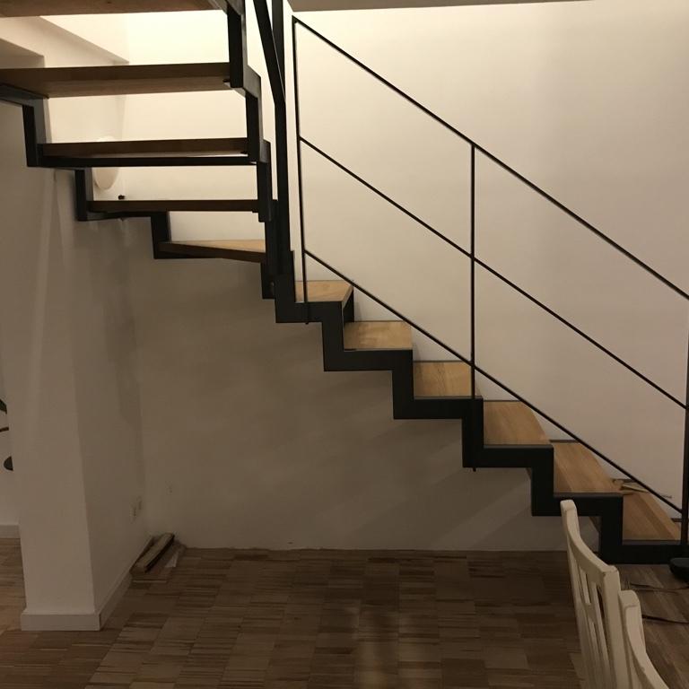Holztreppe mit dunklem Geländer
