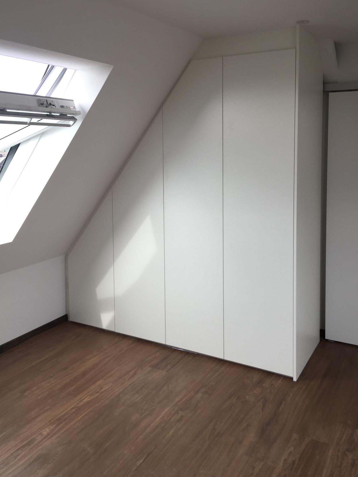 Weißer Dachschrägenschrank Weißer Dachschrägenschrank neben Fenster