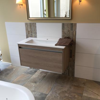 Badezimmerwaschtisch aus Holz und weißem Finish mit einem großen Spiegel darüber.