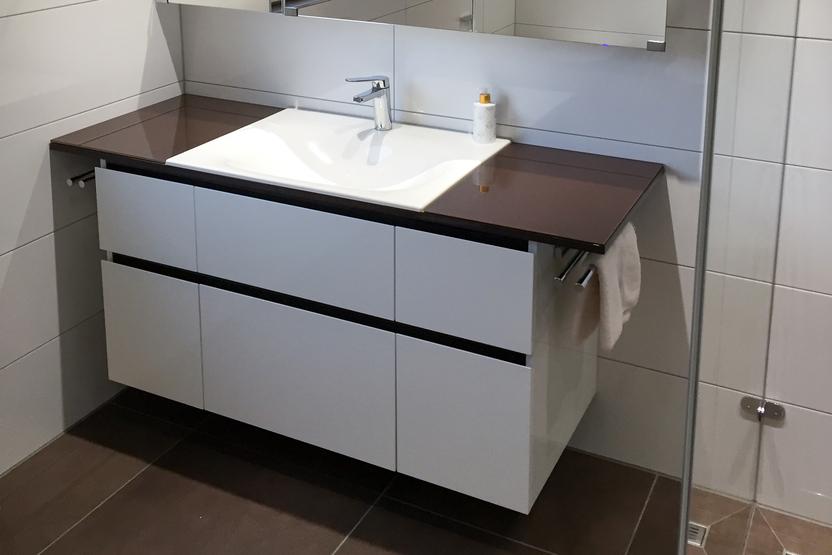 Waschbeckenunterschrank nach Maß Waschbeckenunterschrank mit weißen Fronten und Holzfläche