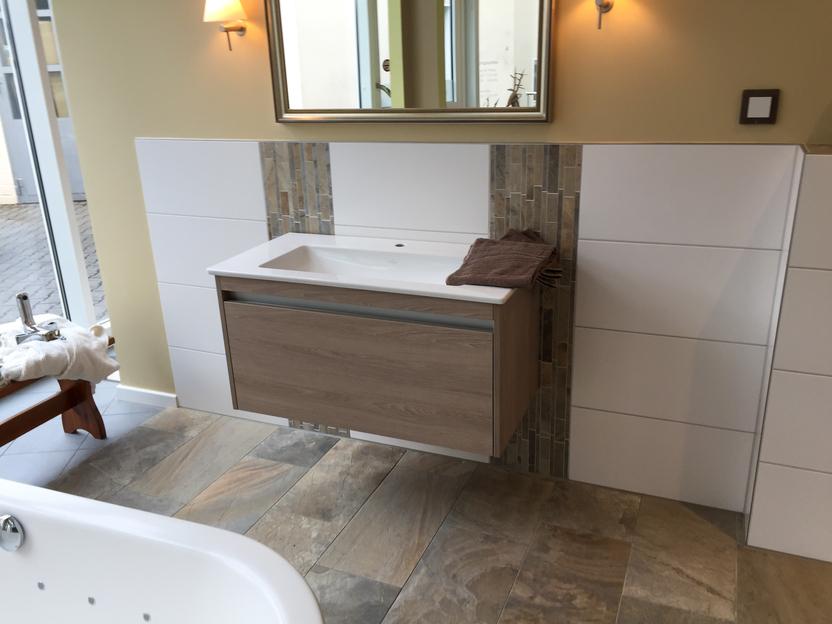 Modernes Badezimmer mit Wandwaschtisch und Spiegel. Badezimmerwaschtisch aus Holz und weißem Finish mit einem großen Spiegel darüber.