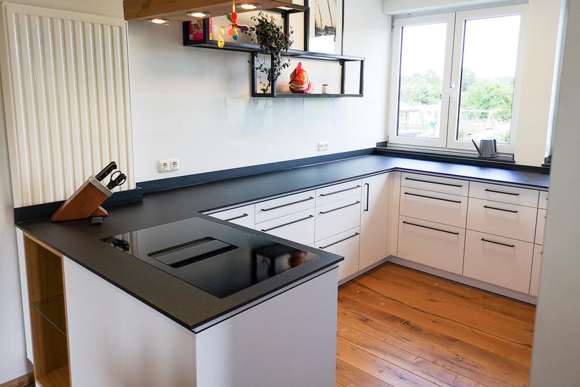 Küchenzeile mit weißen Fronten und dunkler Arbeitsplatte über Eck Küchenzeile mit weißen Fronten und dunkler Arbeitsplatte über Eck