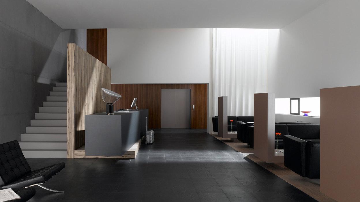 Hotelappartment Untergeschoss mit Holzmobiliar, dunklem Parkett und Treppenaufstieg