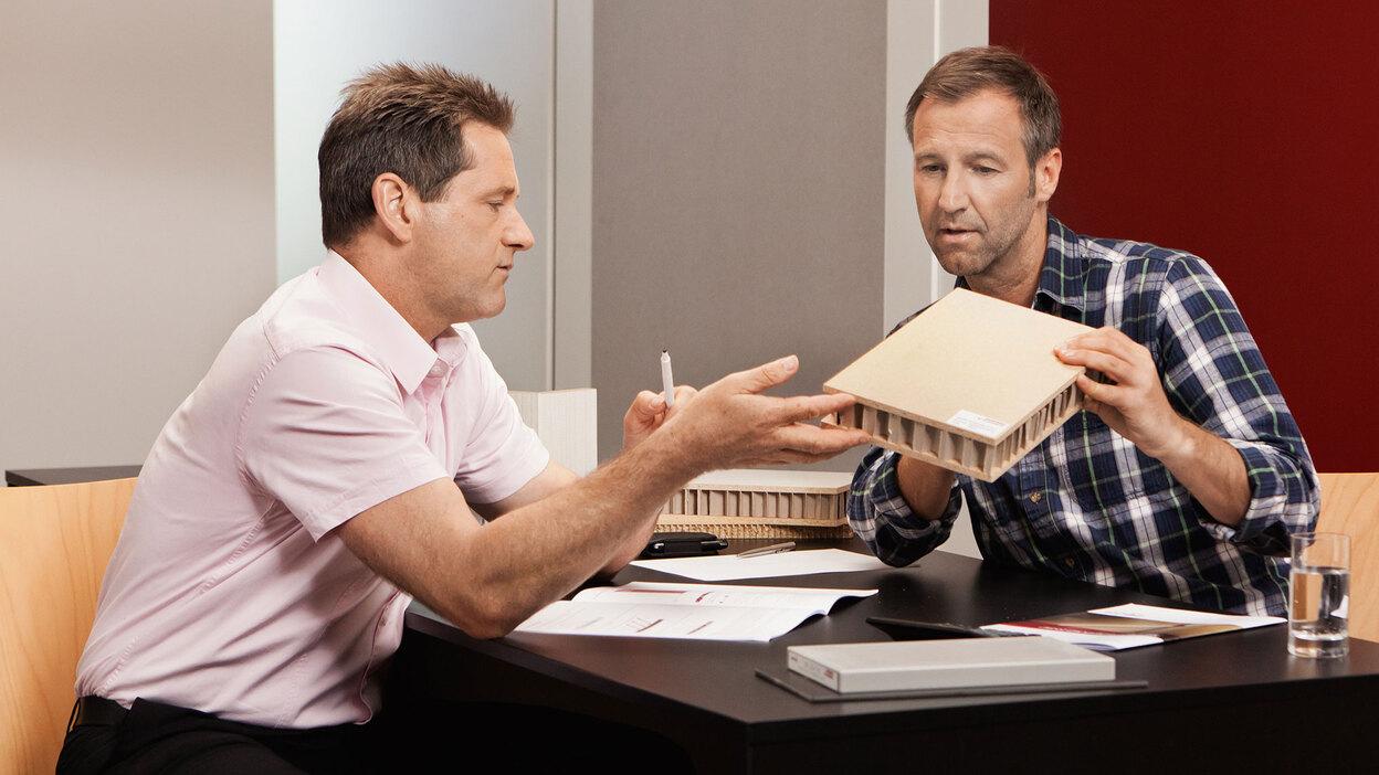 Beratung zu verschiedenen Holzmaterialien und -dichten Detailberatung zu verschiedenen Holzmaterialien -und dichten zwischen zwei Männern